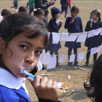 A young girl brushes her teeth at a hygiene workshop during an outreach run by Dentistry interns in Nepal. A child brushes her teeth outside a school during a hygiene workshop run by Projects Abroad Dentistry interns in Nepal.